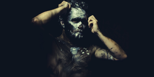 Fight, wild man with white painted face and full body black paint