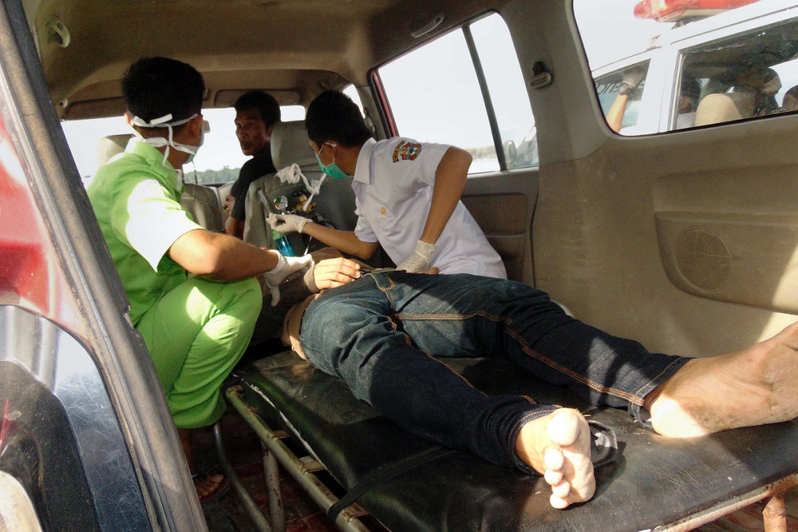 Two Indonesian medical team members help a survivor (C) in Siwa following a ferry accident in central Indonesia off the island of Sulawesi on December 20, 2015.  Two children have become the first victims found following a ferry accident in central Indonesia, an official said on December 20, as search and rescue teams continue scouring the rough seas for survivors.  A total of 23 people have so far been pulled from the water alive off Sulawesi island, where a passenger ferry carrying 118 people ran into trouble in a violent storm late on December 19, a transport ministry spokesman said.       AFP PHOTO / IRWAN KAHIR