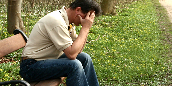desperate man on bench   a sunny summer day   in a village in denmark