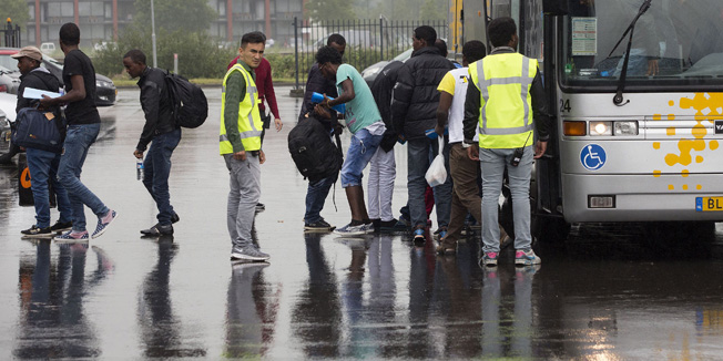 Asylum seekers arrive by bus at the Zeelandhallen in Goes in southwestern Netherlands on July 20, 2015. The halls are being prepared by the Central Agency for the Reception of Asylum Seekers (COA) to shelter refugees. EU ministers are trying to end a stalemate before an end-July deadline to share the burden of 40,000 mainly Syrian and Eritrean migrants who have landed in overstretched Italy and Greece. AFP PHOTO / ANP / ARIE KIEVIT== NETHERLANDS OUT ==
