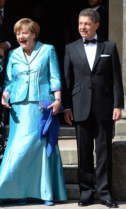 German Chancellor Angela Merkel (L) laughs beside of her husband Joachim Sauer upon arrival for the opening of the Bayreuth Wagner Opera Festival with the production 