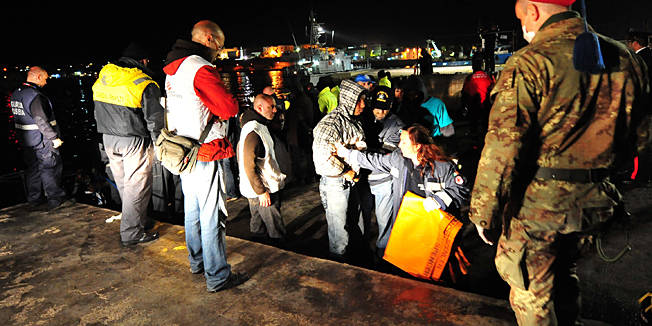 Tunisians would-be immigrant are helped as they arrives in Lampedusa on March 26, 2011. The Italian government says more than 15,000 migrants have arrived on the Italian island from Tunisia since the ouster of president Zine El Abidine Ben Ali in mid-January, including around 13,500 in the last 20 days alone. AFP PHOTO / ALBERTO PIZZOLI