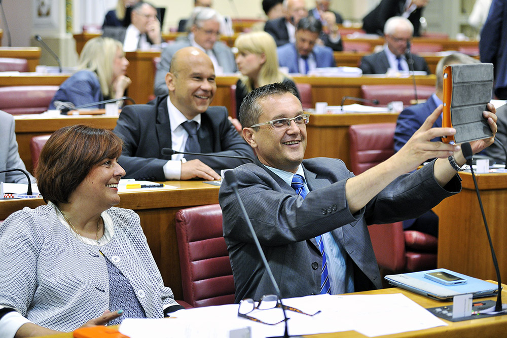 Zagreb, 290715.Hrvatski sabor na izvanrednoj sjednici, sazvanoj na Vladin zahtjev, formalno odlucuje o istupanju Hrvatske iz arbitraznog sporazuma sa Slovenijom. Takodjer, sabornici su na toj sjednici raspravljali o novonastalim okolnostima vezanim uz provedbu Sporazuma o arbitrazi izmedju vlada Hrvatske i Slovenije.Na fotografiji: Goran Beus Richembergh radi 'selfie'.Foto: Boris Kovacev / CROPIX