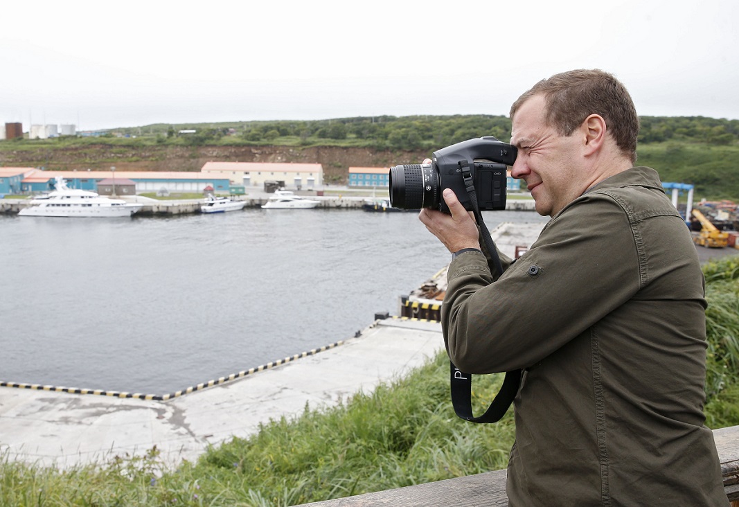 Russian Prime Minister Dmitry Medvedev takes pictures at a port station in the Kitovyi village as he visits Iturup island, one of four islands in the chain that lies off Russia's far eastern coast and just north of Japan, on August 22, 2015. Russian Prime Minister Dmitry Medvedev landed Saturday in the Kuril islands, prompting a swift rebuke from Tokyo, which claims sovereignty over the northwest Pacific archipelago in a long-running dispute. AFP PHOTO / RIA NOVOSTI / DMITRY ASTAKHOV