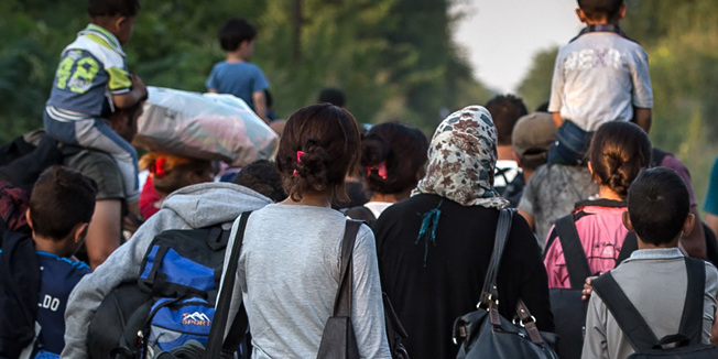 Migrants walk down a railroad towards Hungary near the northern Serbian town of Horgos on August 28, 2015. As Hungary scrambles to ramp up defences on its border with Serbia, refugees continued to surge into the country in record numbers, police figures confirmed.  AFP PHOTO / ANDREJ ISAKOVIC