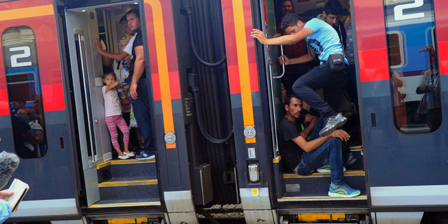 Migrants travel on the train to Austria and Germany at the Eastern (Keleti) railway station in Budapest on August 31, 2015. The EU is grappling with an unprecedented influx of people fleeing war, repression and poverty in what the bloc has described as its worst refugee crisis in 50 years.  AFP PHOTO / ATTILA KISBENEDEK