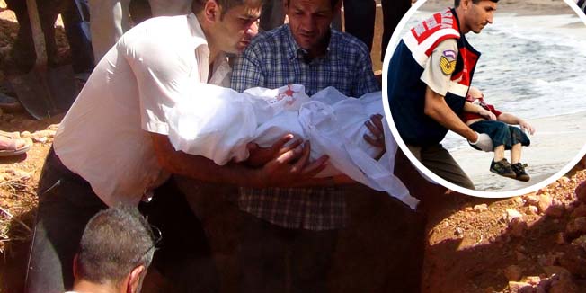 Father of Aylan Kurdi (C), (also know as Aylan Shenu), a three-year-old boy whose drowning off Turkey, holds the body of his child during a funeral ceremony in Kobane, on September 4, 2015. 