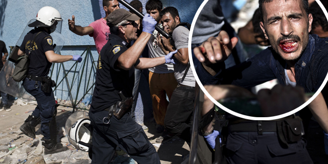 Policemen try to disperse migrants who wait to be registered by the police at the Lesbos Port on September 5, 2015. More than 230,000 refugees and migrants arrived in Greece by sea this year, a huge rise from 17,500 in the same period in 2014, Greek deputy shipping minister Nikos Zois said on September 3, 2015. AFP PHOTO / ANGELOS TZORTZINIS