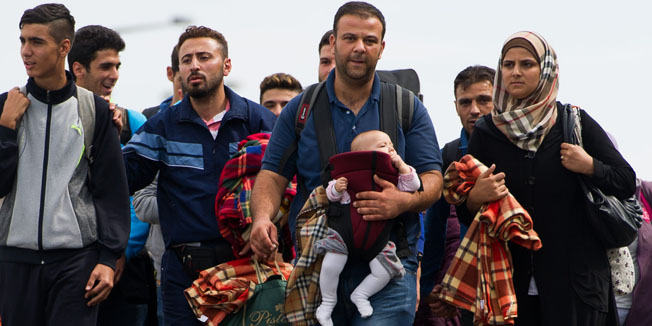 Refugees cross the Austrian - Hungarian border near Heiligenkreuz, Austria, on September 14, 2015. Hungary has effectively stopped registering thousands of migrants crossing the border from Serbia and is transporting them straight to the Austrian frontier, the UN refugee agency said. The migrants, mostly Syrians, Afghans and Pakistanis, seek to travel onwards to Austria and then western Europe, particularly Germany -- which has relaxed asylum rules for Syrians -- and Sweden.    AFP PHOTO / MICHAEL GRUBER