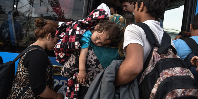 TOPSHOTSMigrants board a bus at the train station in Dugo Selo, near Zagreb on September 17, 2015. A special train transporting some 800 migrants from Tovarnik, near the Serbian border, arrived in Dugo Selo, near Zagreb, Thursday morning. The migrants were being transferred to a reception centre in nearby Jezevo. Since the start of the crisis the Croatian authorities have urged solidarity with migrants, recalling its own role in accommodating hundreds of thousands of refugees and displaced people during the 1990s Balkans wars.  AFP PHOTO / ANDREJ ISAKOVIC