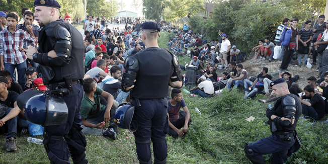 Tovarnik, 170915.U posljepodnevnim satima interventna policija blokirala izbjeglice u ulici Brace Simunic koja vodi sa kolodvora.Na fotografiji: policija i izbjeglice.Foto: Dragan Matic / CROPIX