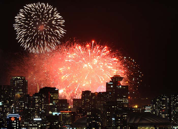 Fireworks explode over the city of Vancouver and the BC PLace (R) during the opening ceremony of the Vancouver Winter Olympics on February 12, 2010.   AFP PHOTO / TOSHIFUMI KITAMURA