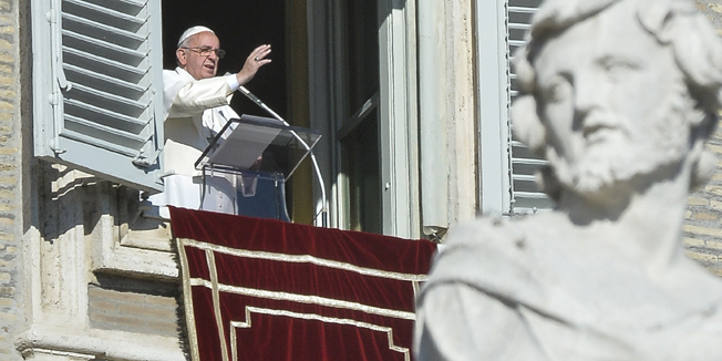 Pope Francis greets the crowd from the window of the Apostolic Palace overlooking St.Peter's square during his Angelus prayer on January 1, 2015 at the Vatican. AFP PHOTO / ANDREAS SOLARO
