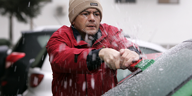 Osijek, 140109.Ledena kisa koja je nocas padala u cijeloj Hrvatskoj stvorila je mnogima probleme, promet je bio otezan zbog smrznutih cesta, automobili su bili okovani ledom, a pjesaci su bili u opasnosti zbog smrznutih gradskih ulica i trgova. Vozac struze led sa vjetrobrana svog automobila.Foto: Vlado Kos / Cropix