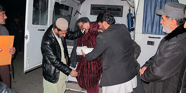 A wounded Afghan woman (C) is brought to the hospital in Helmand province early on January 1, 2015 after a rocket fired during fighting between Afghan forces and insurgents killed at least 15 wedding guests late on December 31. Most of the victims were women and children in the attack in Helmand's Sangin district, a Taliban stronghold where the US and British troops were involved in years of fierce fighting until the NATO withdrawal.     AFP PHOTO / Noor Mohammad