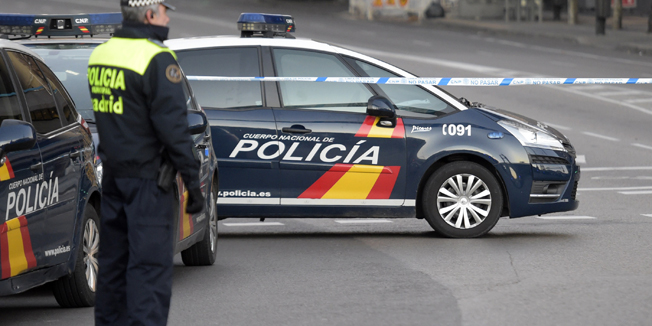 A Spanish policeman stands guard at the entrance of Genova street close to the Spanish Popular Party's headquarters after a man runned his car with two gas cylinders into the political party's building, in Madrid on December 19, 2014. The area in central Madrid was shut off by police as bomb disposal experts examine the car, and the driver, a Spanish buisnessman was arrested, no one was injured.    AFP PHOTO/ GERARD JULIEN