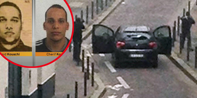 TOPSHOTSArmed gunmen face police officers near the offices of the French satirical newspaper Charlie Hebdo in Paris on January 7, 2015, during an attack on the offices of the newspaper which left eleven dead, including two police officers, according to sources close to the investigation. AFP PHOTO / ANNE GELBARD