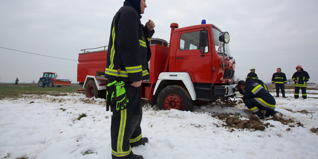 Sodolovci, Osijek, 080115.Vatrogasci koji su pristigli u pomoc obitelji kojoj je gorjela kuca, naposljetku su i sami zatrebali pomoc. Na dojavu o pozaru u obiteljskoj kuci u Sodolovcima doslo je cetrdesetak vatrogasaca iz sest vatrogasnih postrojbi, dobrovoljci iz Semeljaca, Kesinaca, Koritne, Laslova ,Silasa i JPVP iz Osijeka.Nakon sto je pozar ugasen nastao je problem jer je pet vatrogasnih vozila zapalo u blatnoj oranici odakle nisu mogli izaci.Vozila su nakon sat vremena uz pomoc velikih traktora i bagera uspjesno izvucena iz blatne oranice.Na fotografiji: vatrogasna vozila zarobljena u blatu.Foto: Vlado Kos / CROPIX  