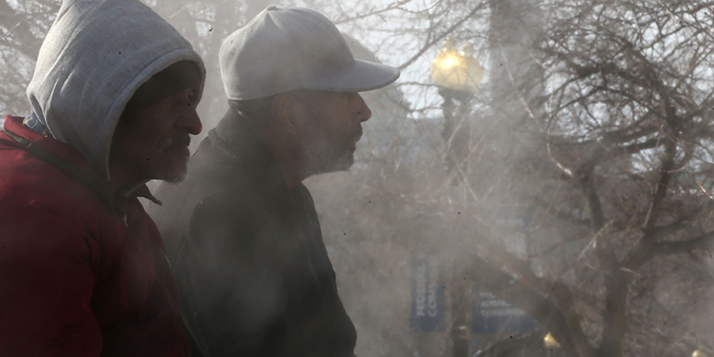 WASHINGTON, DC - JANUARY 08: People sit on a steam grate to keep warm, January 8, 2015 in Washington, DC. The Washington area is experiencing a cold snap with temperatures in the single digits and teens.   Mark Wilson/Getty Images/AFP== FOR NEWSPAPERS, INTERNET, TELCOS & TELEVISION USE ONLY ==