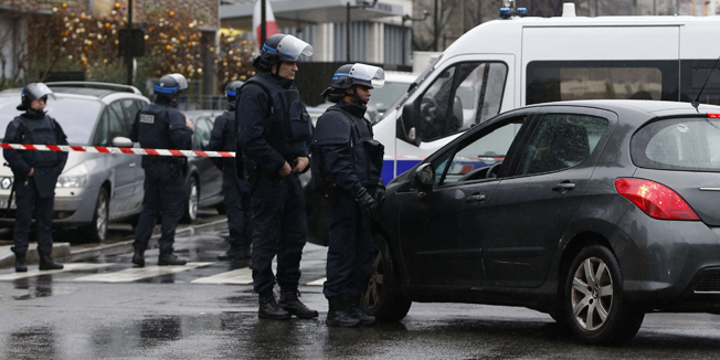 Police officers secure the area near the headquarters of French Central Directorate of Interior Intelligence (DCRI) in Levallois, near Paris, on January 8, 2015 after a policewoman was killed and a city employee seriously hurt when a man opened fire with an automatic rifle outside Paris today. The gunman is still on the run, said French Interior Minister.      AFP PHOTO / KENZO TRIBOUILLARD