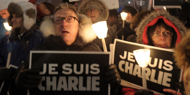 People gather for a vigil January 7, 2015 outside  City Hall in Montreal, Canada  for the victims of the shooting at the office of the French satirical magazine Charlie Hebdo.  Twelve people were killed when several gunmen opened fire at Charlie Hebdo's headquarters in Paris, France on January 7th. AFP PHOTO / MARC BRAIBANT