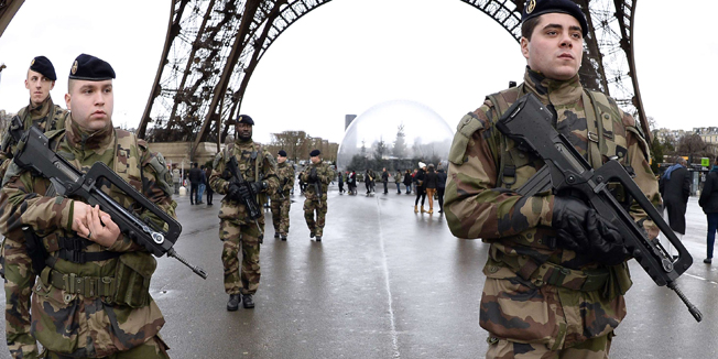 French soldiers patrol in front of the Eiffel Tower on January 8, 2015 in Paris. France announced an unprecedented deployment of thousands of troops and police to bolster security at 