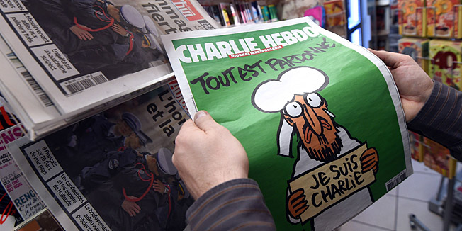 A man displays the latest edition of French satirical magazine Charlie Hebdo shortly after it went on sale on January 14, 2015 in Montpellier. The first issue of satirical magazine Charlie Hebdo to be published since a jihadist attack decimated its editorial staff last week was sold out within minutes at kiosks across France. AFP PHOTO / PASCAL GUYOT