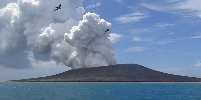 TOPSHOTSThis view taken on January 17, 2015 from a boat at sea shows frigate birds flying on the thermals from the new vent as steam and gas rise from the eruption of a volcano, some 65 kilometres (40 miles) northwest of the South Pacific nation Tonga's capital Nuku'alofa. The Tongan volcano has created a substantial new island since it began erupting in December, spewing out huge volumes of rock and dense ash that has killed nearby vegetation, officials said on January 16.  The Lands and Natural Resources Ministry said the volcano was erupting from two vents, one on the uninhabited island of Hunga Ha'apai and the other underwater about 100 metres offshore.        AFP PHOTO / Matangi Tonga / Mary Lyn Fonua