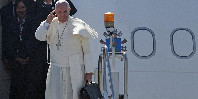 Pope Francis waves to the crowd before he boards his plane during a departure ceremony at Villamor Airbase in Manila on January 19, 2014. Pope Francis flew back to Rome on January 19 after a dramatic week in Asia that saw him draw record crowds and hammer home his pro-poor message to millions.      AFP PHOTO / NOEL CELIS