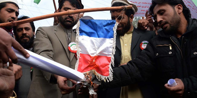 Afghan demonstrators set a French flag on fire during a protest against the printing of satirical sketches of the Prophet Muhammad by French magazine Charlie Hebdo in Jalalabad on January 19, 2015. Hundreds of people on January 19 demonstrated against the publication of caricatures by French weekly Charlie Hebdo, burning the French flag in eastern Afghanistan.The demonstrators in the city of Jalalabad the capital of Nangarhar province chanted anti-France slogans and asked the Afghan government to cut off diplomatic relation with France.  AFP PHOTO / NOORULLAH SHIRZADA