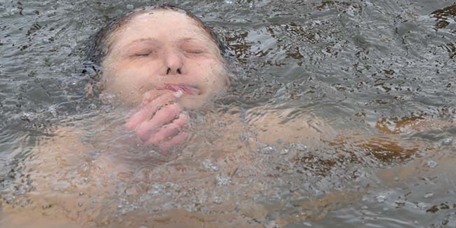 An Orthodox faithful dips into the icy waters of a lake on January 19, 2015 during the celebration of the Epiphany holiday near the village of Sretinka, some 40 kms from Bishkek. Among Orthodox Christians, the feast of Epiphany celebrates the day the spirit of God descended upon believers in the shape of a dove during Jesus Christ's baptism in the river Jordan.  AFP PHOTO / VYACHESLAV OSELEDKO