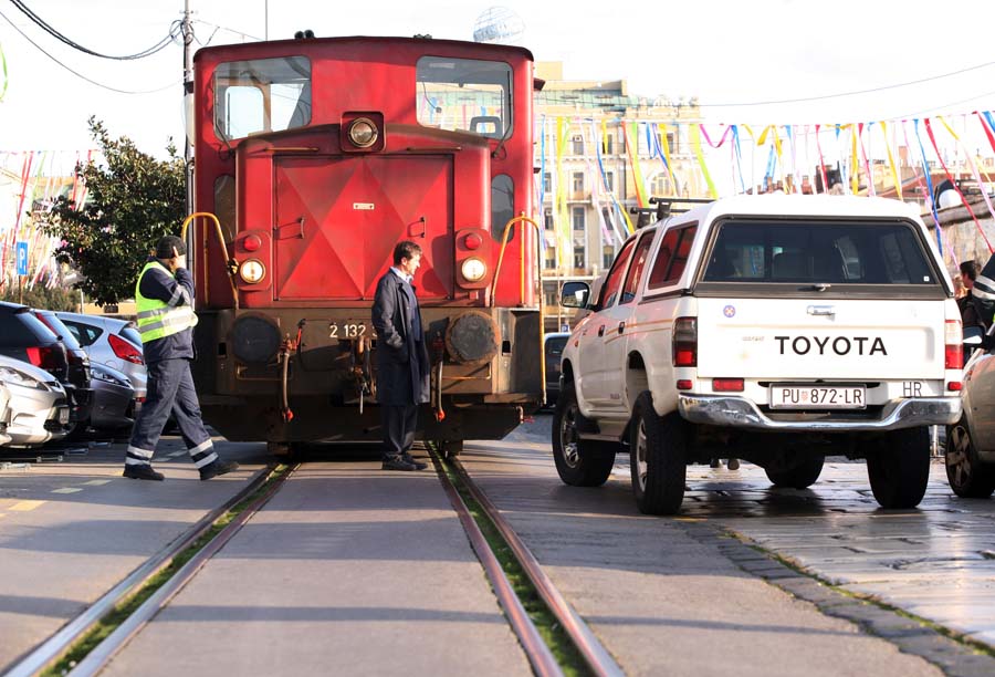 Rijeka, 260115.Prometni cep na Rivi i okolnim ulicama nastalo je uslijed nepropisnog parkiranja nesavijesnog vozaca. Zbog automobila parkiranog tik uz tracnice onemogucen je prolazak vlaka koji prometuje Rivom, a zastoj vlaka protpuno je blokirao ulaz i izlaz s parkiralista te pjesacku komunikaciju.Foto: Tea Cimas / CROPIX