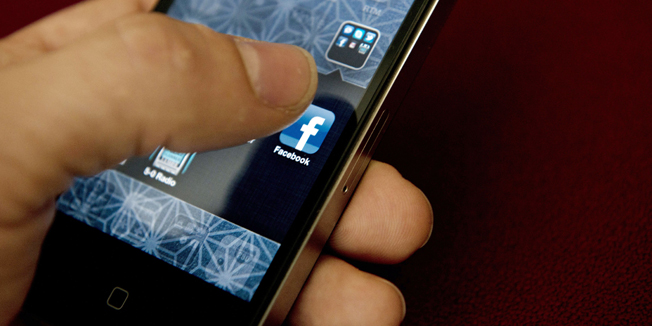 (FILES) This May 10, 2012 file photo shows a view of an Apple iPhone displaying the Facebook app's splash screen in Washington, DC.  Facebook said January 26, 2015 it is testing a lightweight version of its mobile app for mobile phones with poor-quality Internet connections in emerging markets. A spokesman told AFP in an email that the 