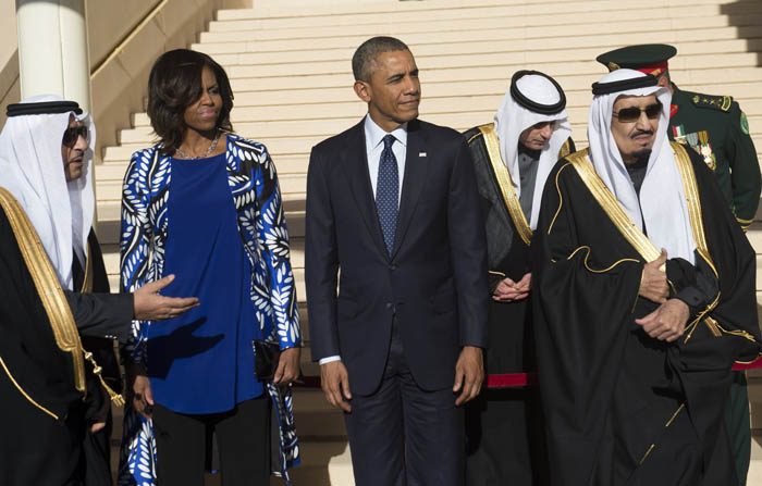 Saudi new King Salman (R) stands alongside US President Barack Obama (C) and First Lady Michelle Obama (2nd from L) after the Obamas arrived on Air Force One at King Khalid International Airport in Riyadh on January 27, 2015. Obama landed in Saudi Arabia to shore up ties with new King Salman and offer condolences after the death of his predecessor Abdullah. AFP PHOTO / SAUL LOEB