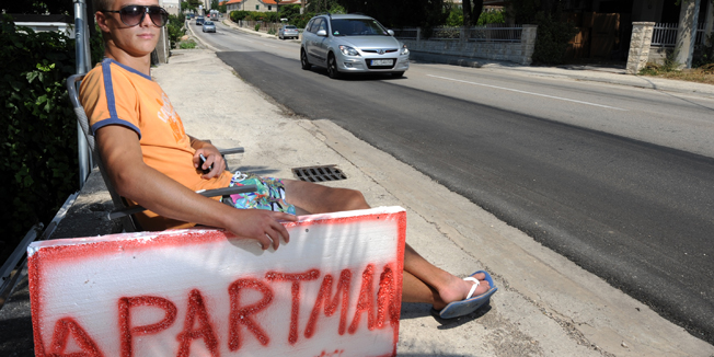 Split,180714.Uslijed pomanjkanja turista privatni iznajmljivaci od Splita do Omisa prisiljeni su sjediti uz cestu i bannerima privlaciti potencijalne turiste.Na fotografiji Zvonko Caktas.Foto: Paun Paunovic / CROPIX