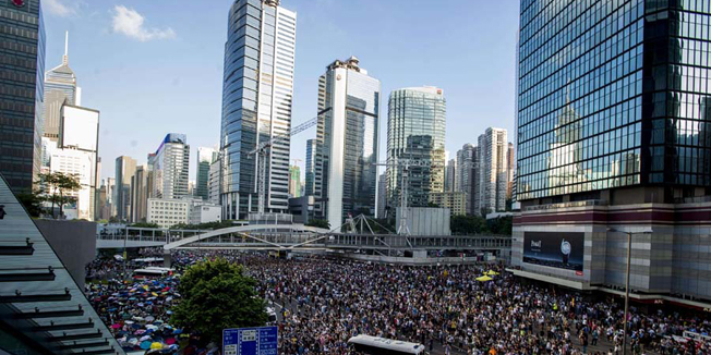 Pro-democracy demonstrators rally near the Hong Kong government headquarters on September 28, 2014. Police fired tear gas as tens of thousands of pro-democracy demonstrators brought parts of central Hong Kong to a standstill on September 28, in a dramatic escalation of protests that have gripped the semi-autonomous Chinese city for days. AFP PHOTO / XAUME OLLEROS