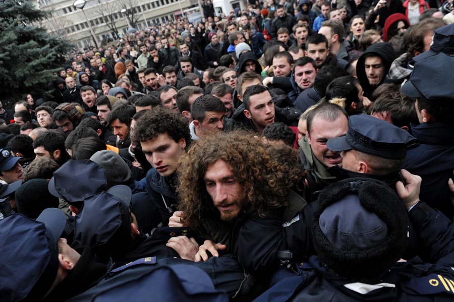 Protesters confront with policemen during a demonstration, in front of the local education authority of Pristina's University, to ask for the resignation of the university's chancellor Ibrahim Gashi and the removal of scientific titles for professors that have published in false scientific magazines, on February 6, 2014. AFP PHOTO/ARMEND NIMANI