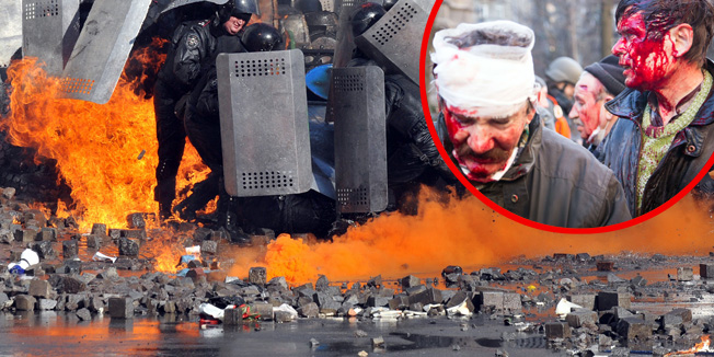 TOPSHOTSAnti-government protesters shield themselves during clashes with riot police in central Kiev on February 18, 2014. Five people died on February 18 as anti-government protesters clashed with security forces in central Kiev, a police spokeswoman said. 