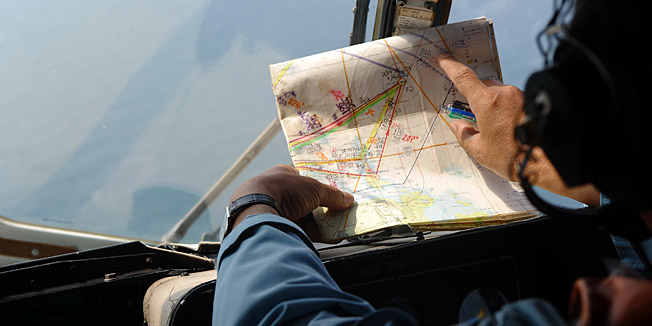 TOPSHOTSThis picture taken aboard a Vietnamese Air Force Russian-made MI-171 helicopter shows a crew member checking a map during a search flight some 200 km over the southern Vietnamese waters off Vietnam's island Phu Quoc on March 11, 2014 as part of continued efforts aimed at finding traces of the missing Malaysia Airlines MH370. Malaysian police said on March 11 one of two suspect passengers who boarded a missing passenger jet was an Iranian illegal immigrant, as relatives of some of the 239 people on board said they were losing hope for a miracle.     AFP PHOTO / HOANG DINH NAM