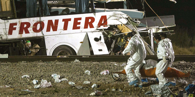 Forensic personnel gather the bodies of victims of a bus crash in Anahuac, Nuevo Leon state on February 14, 2015. At least 16 people were killed and 30 injured when a freight train slammed into a packed passenger bus in northeastern Mexico on February 13, authorities said, warning the death toll could rise. The collision happened when the bus was attempting to cross the rail tracks in the city of Anahuac, Nuevo Leon state, Mexico  AFP. AFP PHOTO/Julio Cesar Aguilar
