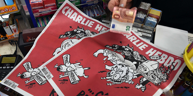 A woman buys the latest edition of French satirical weekly newspaper Charlie Hebdo at a newsstand in Montpellier on February 25, 2015. More than a month after jihadist gunmen massacred much of the Charlie Hebdo editorial staff, the magazine is back at work with another savage swipe at its favourite enemies. The team has lain low since rushing out a 