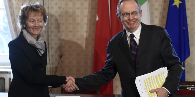 Italian Finance Minister Pier Carlo Padoan (R) and Swiss Federal Counceler Eveline Widmer-Schlumpf sign a protocol on February 23, 2015 modifying the constitution to avoid double taxation between Italy and Switzerland in Milan.   AFP PHOTO / OLIVIER MORIN