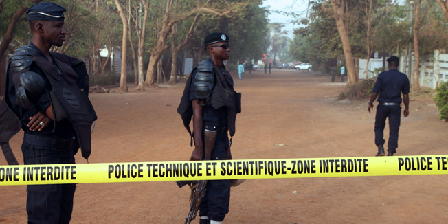 Policemen stand in a street near La Terrasse restaurant, in Bamako on March 7, 2015, after five people, including a French and a Belgian national, were shot dead overnight in the restaurant in a suspected terror attack. A third European, whose nationality was not immediately clear, died on arrival at the Gabriel Toure hospital in Bamako, a source there said, adding that eight people were wounded.   AFP PHOTO / SEBASTIEN RIEUSSEC