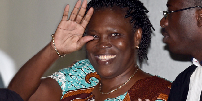 Ivory Coast's former first lady Simone Gbagbo waves as she arrives at the Court of Justice in Abidjan, on February 23, 2015 for her trial along with others for 