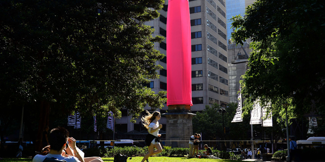 A gaint condom is seen over a heritage-listed obelisk at Hyde Park in Sydney on November 7, 2014. An 18-metre (60-foot) bright pink condom raised eyebrows in Sydney after it was erected over a Sydney landmark as part of a new awareness campaign about HIV. AFP Photo / SAEED KHAN