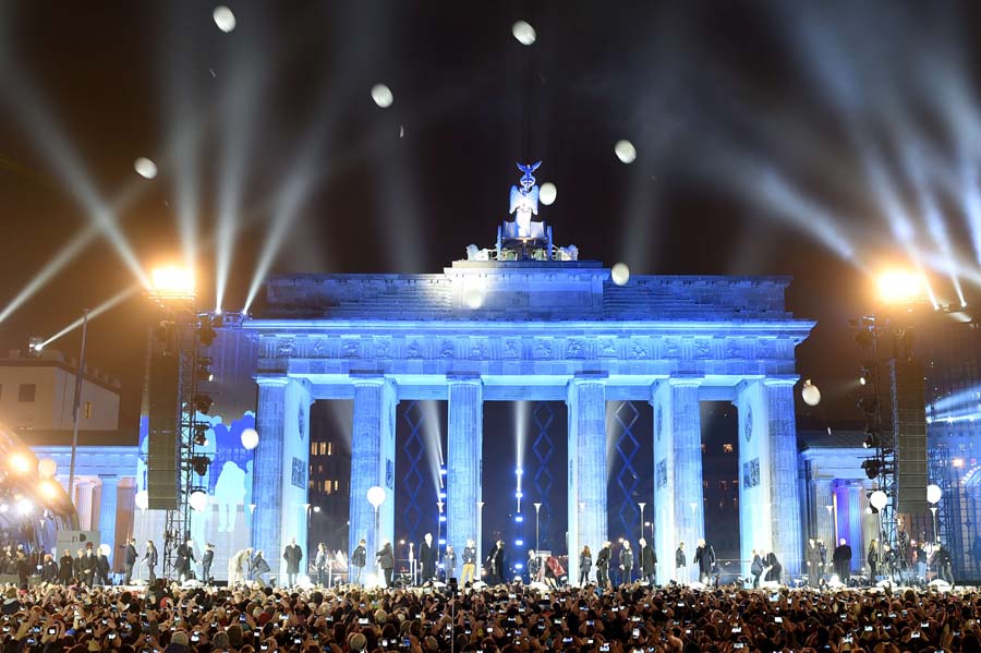 Balloons of the light installation Lichtgrenze sail into the night from the former route of the Berlin Wall during a Street Party organized by German governement to mark the 25th anniversary of the fall of the Berlin Wall, in front of the Brandenburg Gate on November 9, 2014 in Berlin. AFP PHOTO / ODD ANDERSEN
