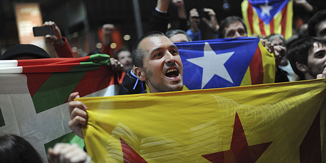 Pro-independence people hold a Catalan independence flag during a meeting organised by the Catalonia National Assembly (ANC) and the Omnium Cultural civil society association after a symbolic vote on independence for Catalonia from Spain at a polling station in Barcelona on November 9, 2014. One of Spain's biggest and richest regions, Catalonia defied Madrid today and proceeded with a symbolic vote on whether it should break away as an independent state.   AFP PHOTO/ JOSEP LAGO