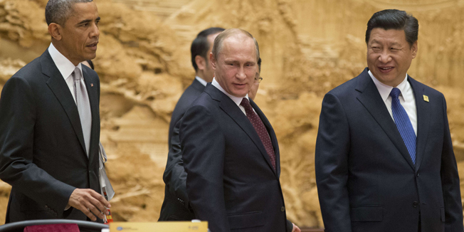 US President Barack Obama (L), Chinese President Xi Jinping (R) and Russian President Vladimir Putin arrive at the Asia-Pacific Economic Cooperation (APEC) Summit plenary session at the International Convention Center in Beijing on November 11, 2014.  Top leaders and ministers of the 21-member APEC grouping are meeting in Beijing from November 7 to 11. AFP Photo/Pablo Martinez Monsivais/POOL