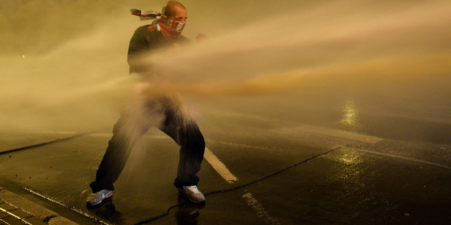 A right-wing nationalist protester is hit by a water cannon used by the police during a far-right annual march that coincides with Poland's National Independence Day in Warsaw on November 11, 2014. Poland's National Independence Day commemorates the anniversary of the Restoration of a Polish State in 1918. AFP PHOTO/JANEK SKARZYNSKI