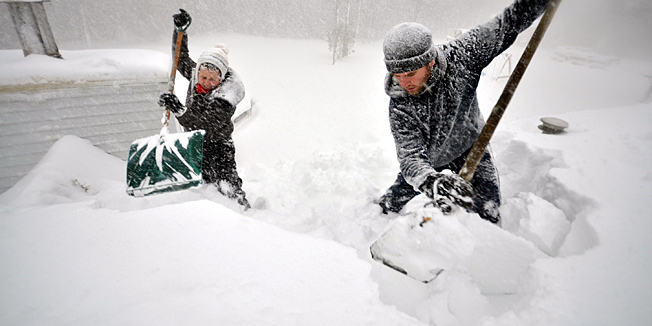 BUFFALO, NY - NOVEMBER 20, 2014: Tami Normile and Richard Brooks attempt to remove some of the five feet of snow from a roof top on November 20, 2014 in the Lakeview neighborhood of Buffalo, New York.The record setting Lake effect snowstorm dumped up to six feet of snow in less than 24 hours closing a one hundred mile section of The New York State Thruway as well as other major roads around Buffalo. Seven deaths have already been attributed to the storm and a second round beginning late Wednesday evening will bring up to three more feet of snow overnight and into Thursday.   John Normile/Getty Images/AFP== FOR NEWSPAPERS, INTERNET, TELCOS & TELEVISION USE ONLY ==